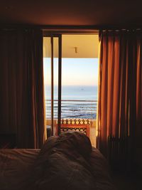 Scenic view of sea against sky during sunset seen through window