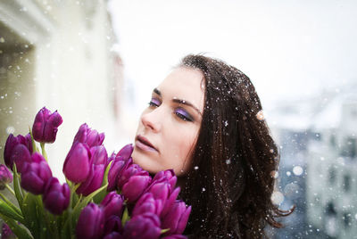 Portrait of woman with pink flower in winter