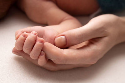 Cropped image of baby on bed