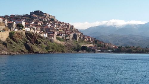 Scenic view of town by sea against sky