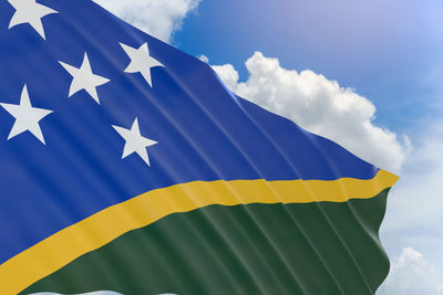 Low angle view of flag against blue sky