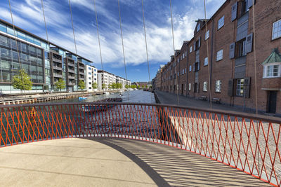 Footpath amidst buildings against sky in city