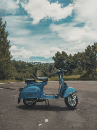 Motor scooter on road against sky