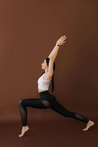 Beautiful athletic female yogin practicing yoga asana anjaneyasana - a low lunge pose