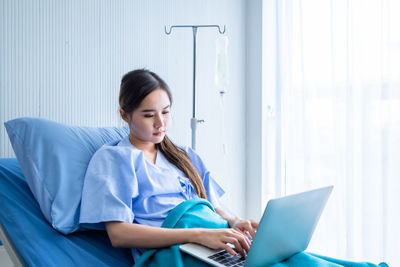 Young woman using laptop while sitting at home