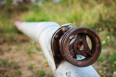 Close-up of rusty pipe on field