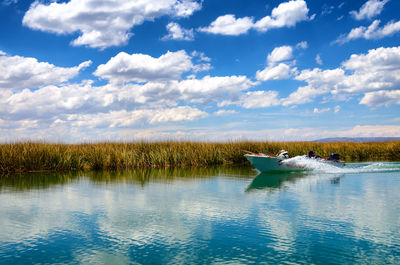 Boat moored in water against sky