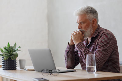 Young man using laptop at table