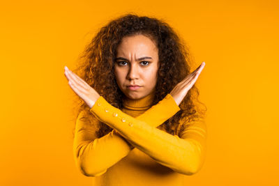 Portrait of woman with yellow hair against orange background