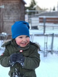 Smiling boy standing in warm clothing during winter