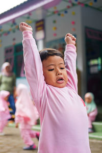 Portrait of cute girl with pink petals in background