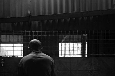 Rear view of man standing in old building