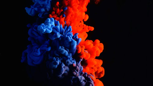 Close-up of blue and red liquid over black background