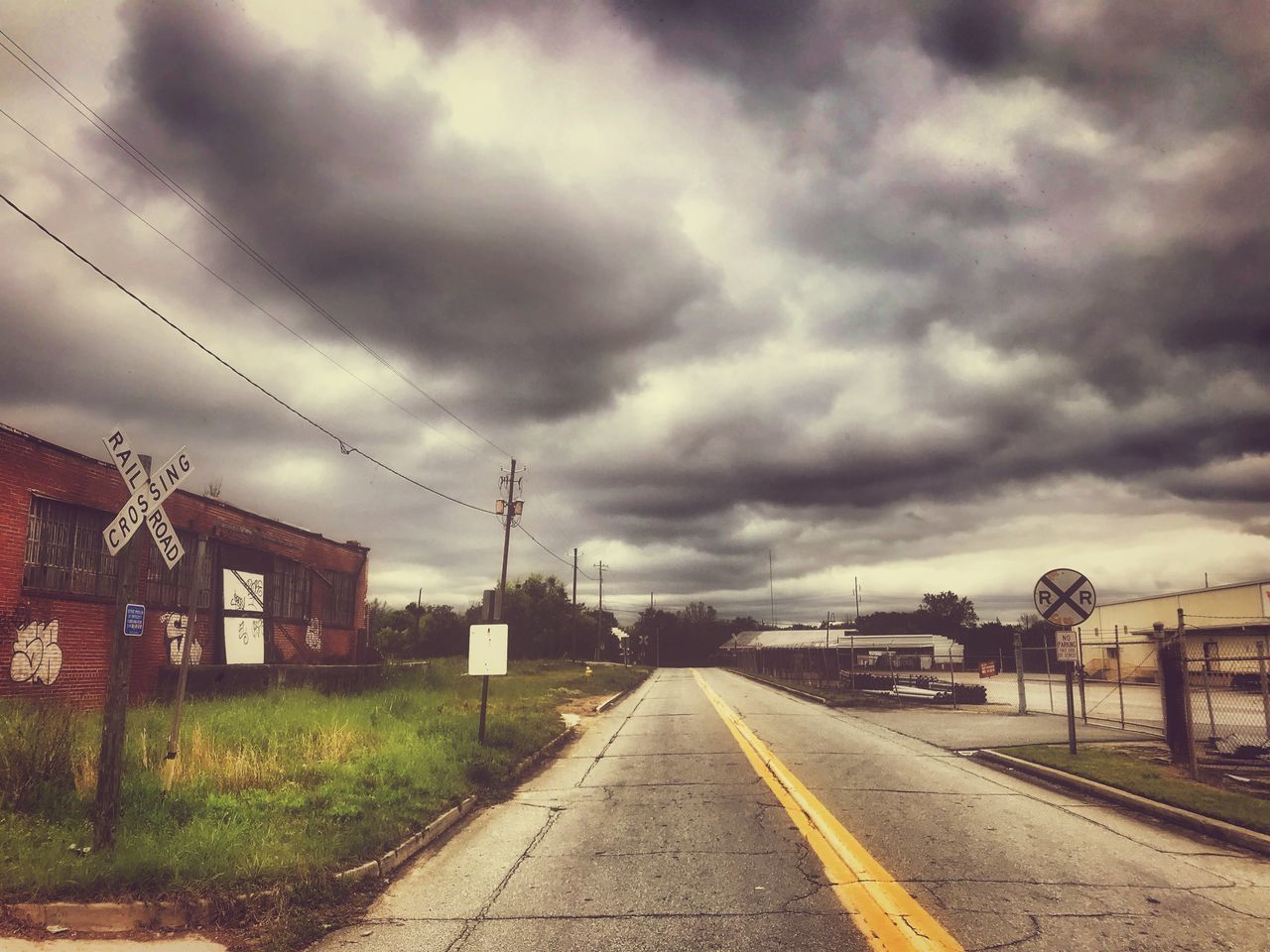 VIEW OF RAILROAD TRACKS AGAINST CLOUDY SKY AND TRAIN