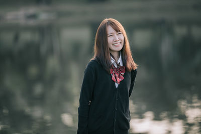 Portrait of a smiling young woman standing outdoors