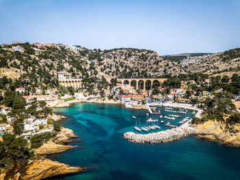 Scenic view of sea by buildings against clear blue sky