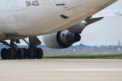 Airplane at airport runway against sky