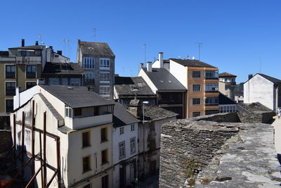 Buildings in town against clear blue sky