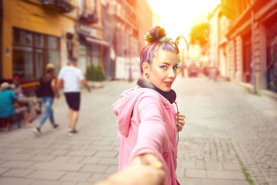 Portrait of happy girl on footpath in city