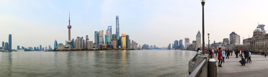 The bund with cityscape and river against sky