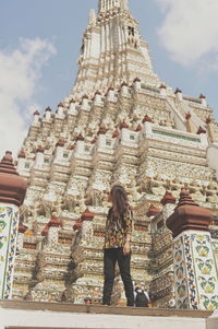 Low angle view of woman standing at historic building