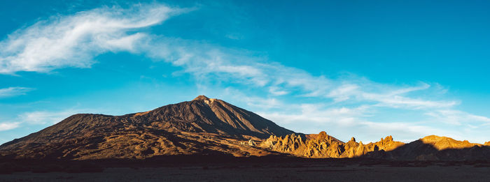 Scenic view of mountain against blue sky