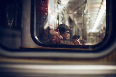 Reflection of man seen through glass window