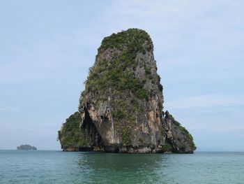 Rock formation in sea against sky