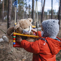 Rear view of woman with toy in park during winter