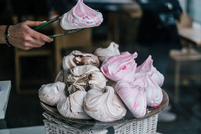 Cropped image of hand holding food with serving tongs