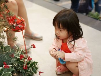 Full length of cute girl and woman standing by flowers