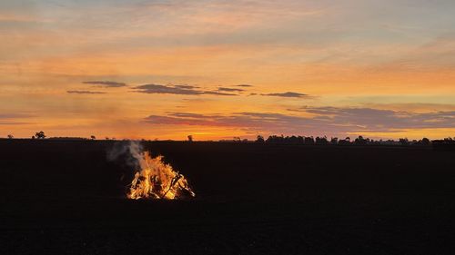 Scenic view of silhouette field against sky during sunset