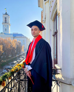 Full length of teenage boy standing against building