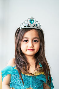 Portrait of a smiling girl wearing tiara and princess costume.