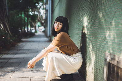 Portrait of young woman sitting outdoors