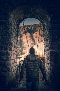 Rear view of man standing on bridge