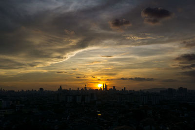 View of cityscape against cloudy sky during sunset