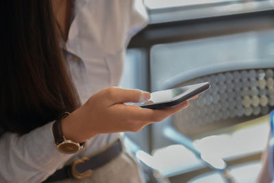 Midsection of woman using mobile phone