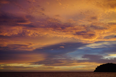 Scenic view of sea against dramatic sky during sunset