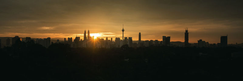 Silhouette buildings against sky during sunset