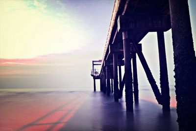 Pier on sea at sunset