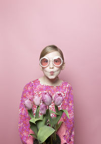 Mod blonde tween girl, blue eyes, pink background, pink floral dress