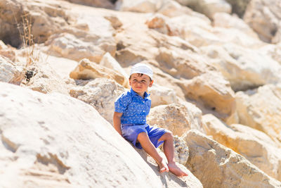 Full length portrait of woman standing on rock