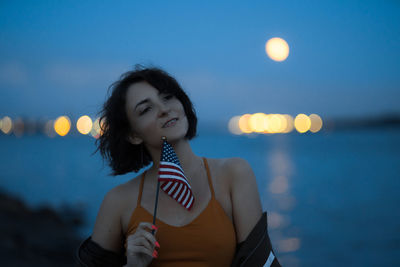 Full length portrait of woman standing against sea