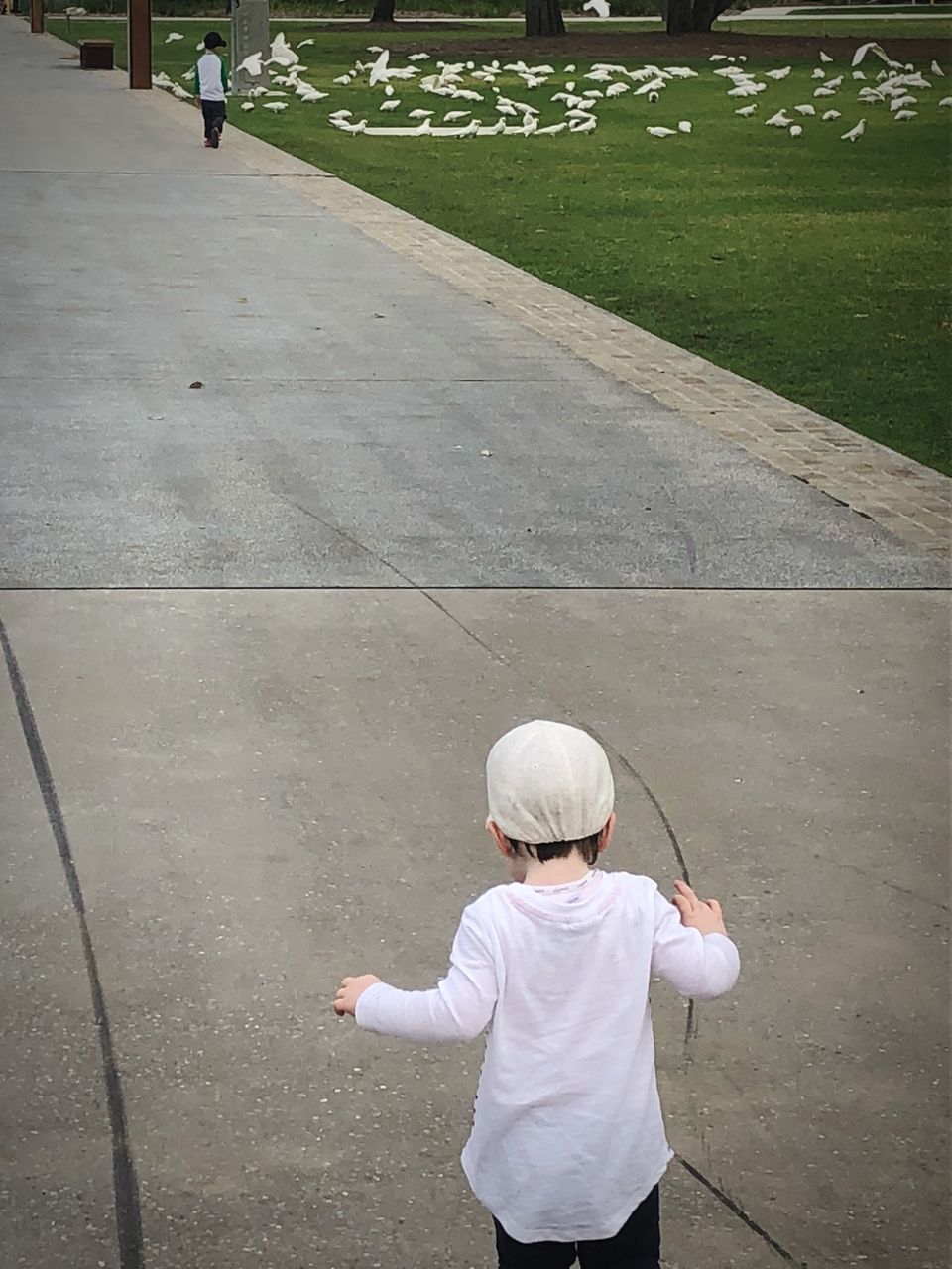 REAR VIEW OF A BOY STANDING ON THE GROUND