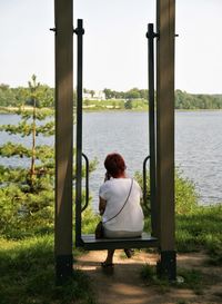 Rear view of woman sitting on swing