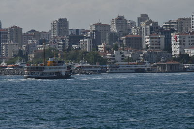 Sea by buildings against sky in city