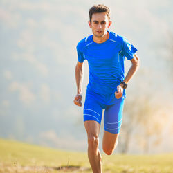 Portrait of man running on field