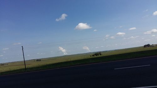 Scenic view of grassy field against cloudy sky