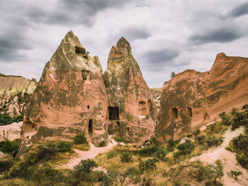 View of rock formations on landscape against cloudy sky